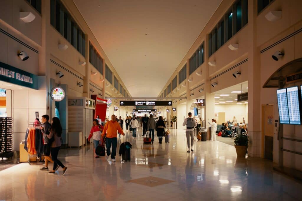 Crowds navigating a bright and busy airport terminal hallway capturing travel dynamics indoors representing documents for green card holder