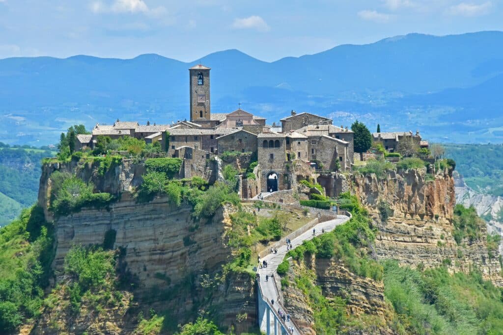 Scenic view of Civita di Bagnoregio perched on a cliff with mountain backdrop