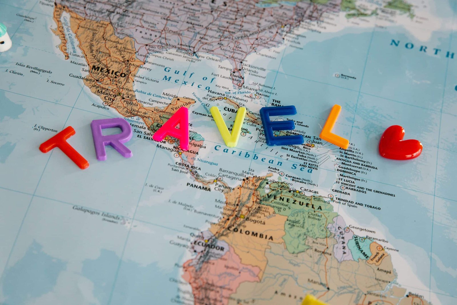 A vibrant map with colorful letters spelling 'TRAVEL', highlighting Central America and the Caribbean.